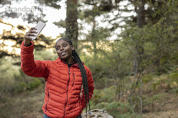 Lächelnde junge Frau  die ein Selfie mit dem Smartphone macht