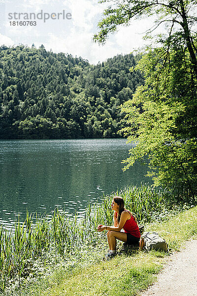 Frau verbringt ihre Freizeit an einem sonnigen Tag in der Nähe des Levico-Sees