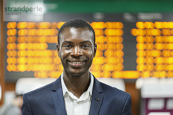 Happy young businessman at railroad station