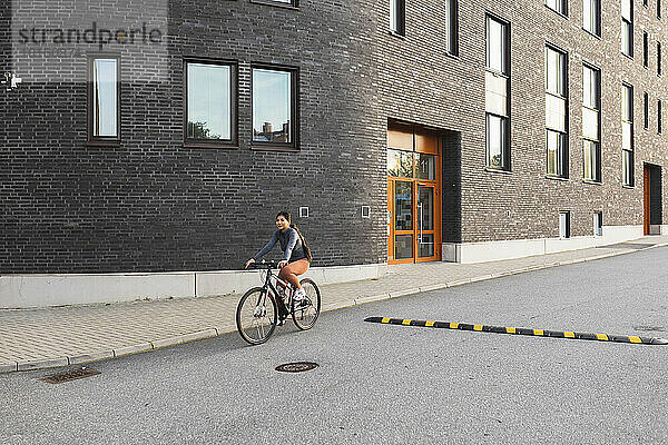 Junge Frau fährt Fahrrad auf der Straße