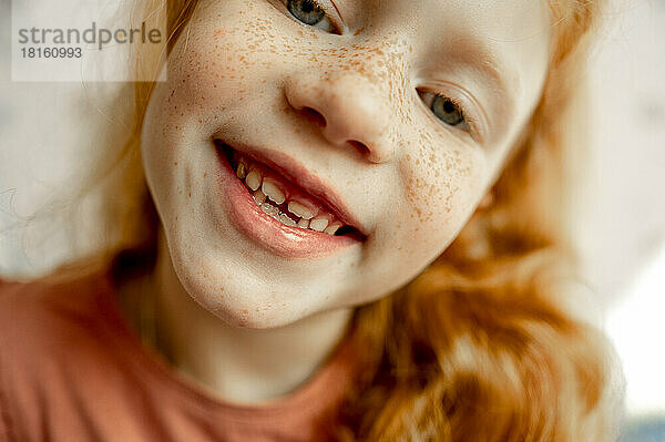 Cute smiling girl with redhead and freckles