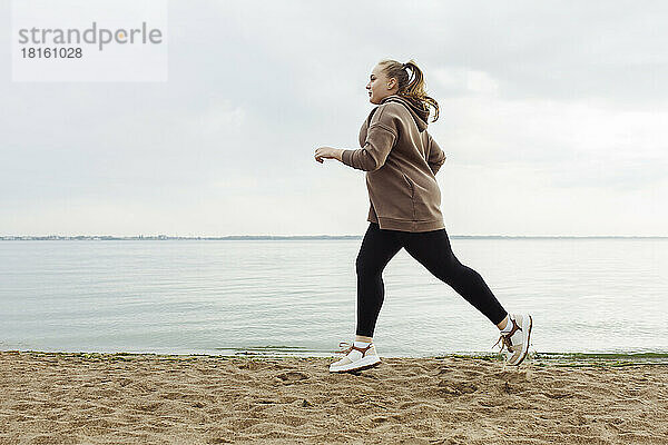 Junge Frau joggt am Strand