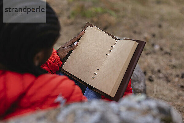 Junge Frau liest Buch im Wald