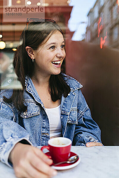 Nachdenkliche Frau in Jeansjacke im Café