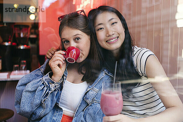 Young lesbian couple enjoying drinks at cafe