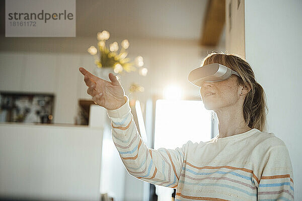 Frau hat Spaß daran  zu Hause ein Virtual-Reality-Headset zu tragen