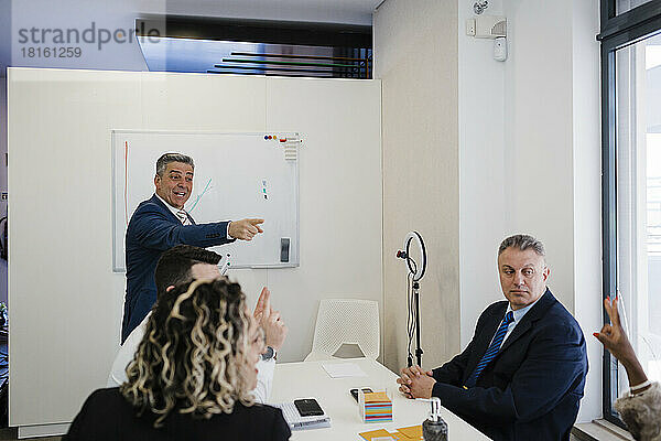 Reifer Geschäftsmann bespricht Strategie mit Kollegen bei Treffen im Büro