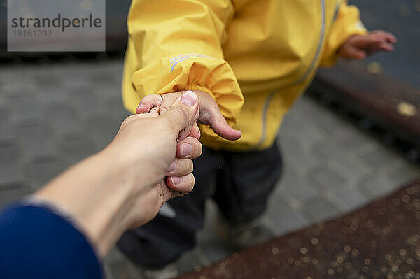 Mother holding son's hand at park