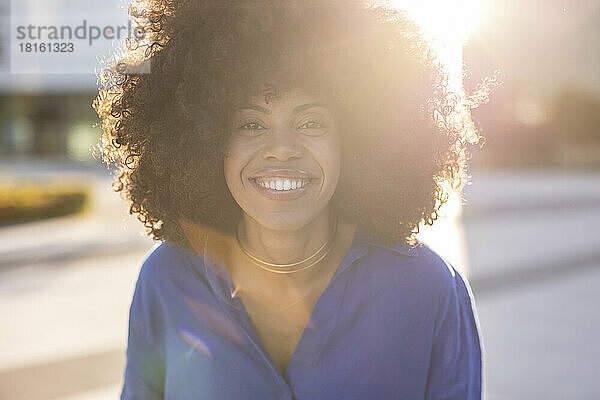 Happy woman with Afro hairstyle on sunny day
