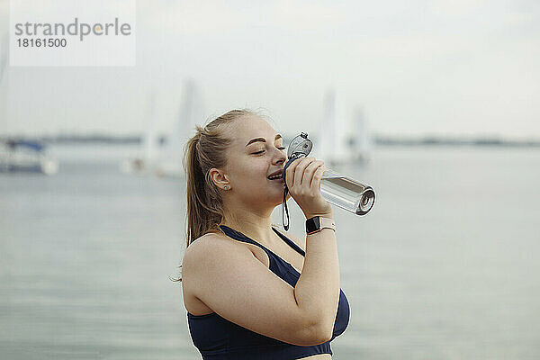 Frau trinkt Wasser nach dem Training