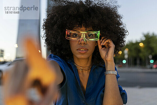 Afro-Frau trägt in der Abenddämmerung eine intelligente Brille