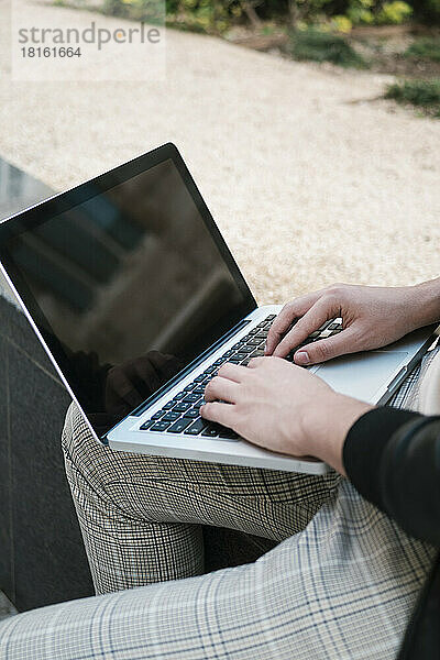 Hände eines Studenten mit Laptop an der Wand