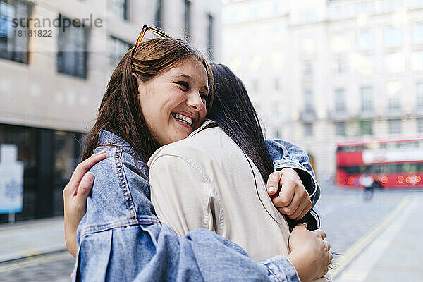 Glückliche junge Frau umarmt lesbische Freundin