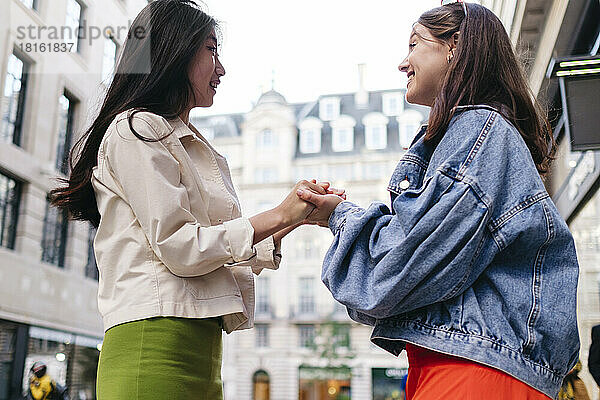 Lesbian women holding hands standing in city