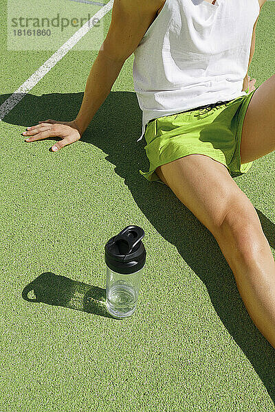 Sportler entspannt sich an einem sonnigen Tag auf dem Sportplatz