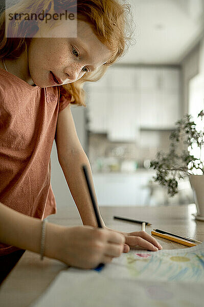 Girl drawing with color pencil at home