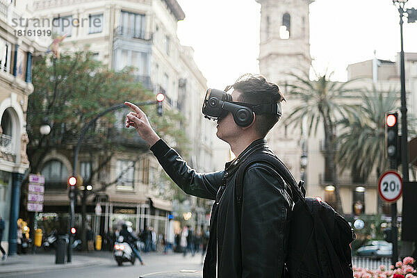 Mann mit futuristischer Brille gestikuliert auf der Straße in der Stadt