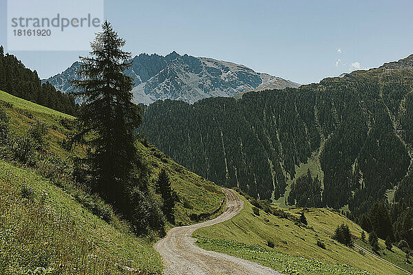 Schweiz  Kanton Graubünden  kurvenreicher Wanderweg in den Samnaun-Alpen mit dem Berg Piz Mundin im Hintergrund