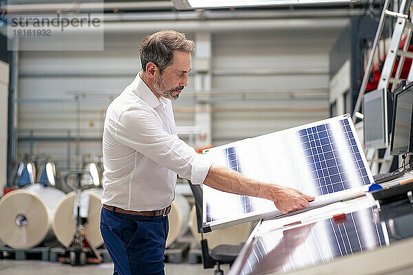 Reifer Geschäftsmann analysiert Solarpanel in der Industrie