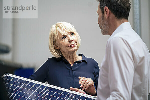 Ältere Geschäftsfrau und Kollegin diskutieren über Solarpanel