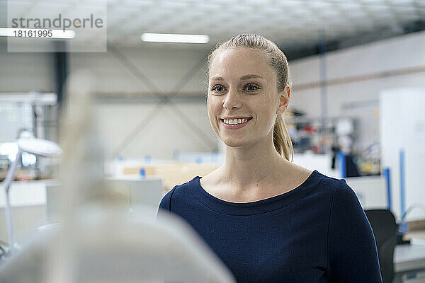 Smiling young businesswoman in industry