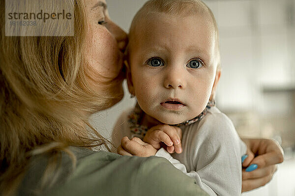 Mother embracing baby girl at home