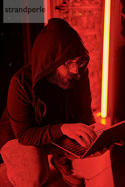 Hacker benutzt Laptop und kauert im Rechenzentrum