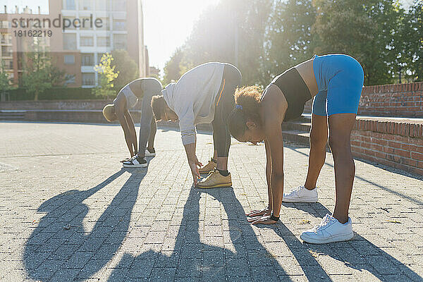 Junge Sportfreunde trainieren auf dem Fußweg