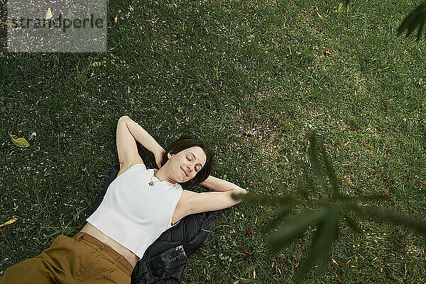 Frau mit geschlossenen Augen entspannt im Garten