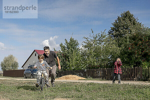 Vater bringt Jungen das Fahrradfahren bei
