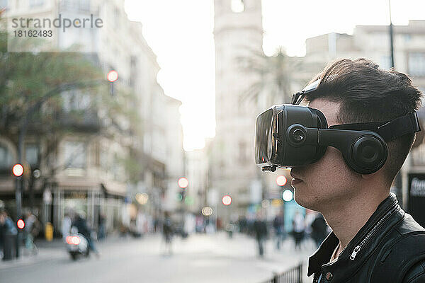 Junger Mann mit VR-Brille in der Stadt