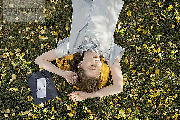 Junge Frau entspannt sich im Herbstpark