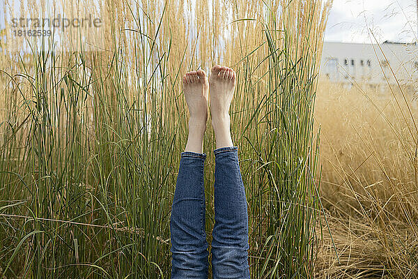 Frau mit erhobenen Füßen vor dem Gras