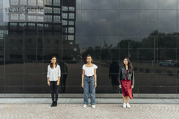 Young women in front of glass wall with reflection