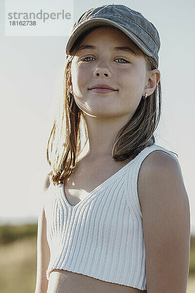 Lächelndes Mädchen mit Mütze an einem sonnigen Tag