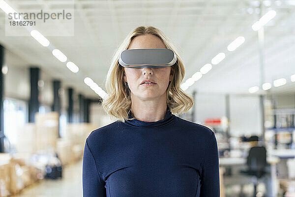 Blonde Geschäftsfrau trägt Virtual-Reality-Simulator in der Industrie