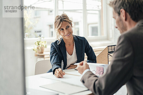 Geschäftsfrau bespricht mit dem Kunden die Lesevereinbarung im Büro