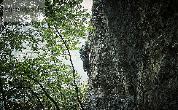 Reife Frau klettert Berg im Wald