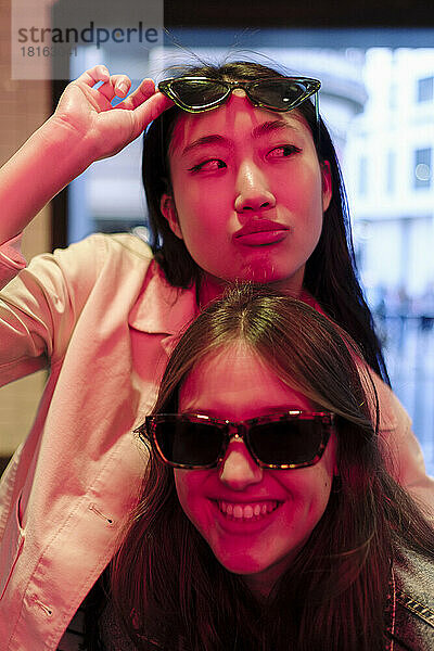 Woman looking sideways with lesbian friend wearing sunglasses