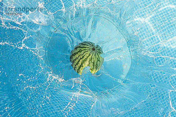 Wassermelone fällt ins Schwimmbad