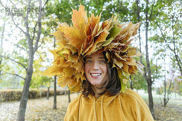 Glückliche Frau mit Herbstkranz auf dem Kopf