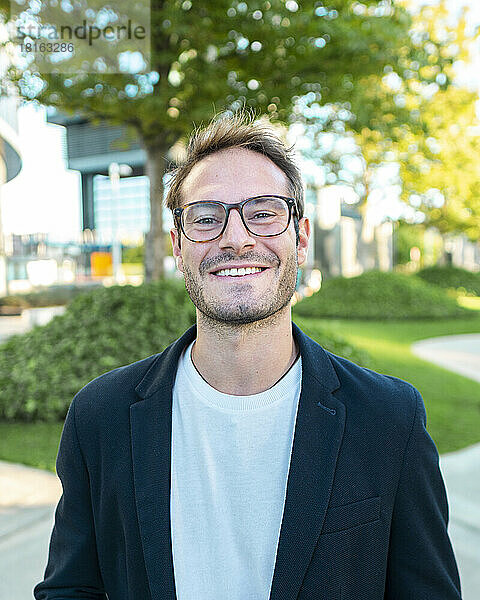 Lächelnder Geschäftsmann mit Brille im Büropark