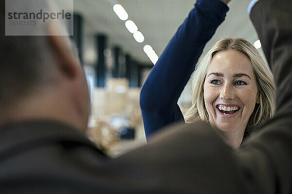 Cheerful businesswoman giving high-five to colleague