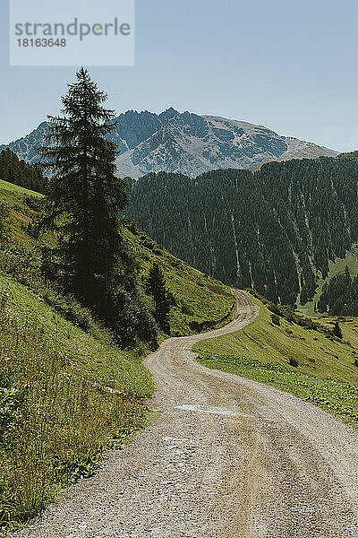 Schweiz  Kanton Graubünden  Gewundener Wanderweg in den Samnaun-Alpen mit dem Berg Piz Mundin im Hintergrund