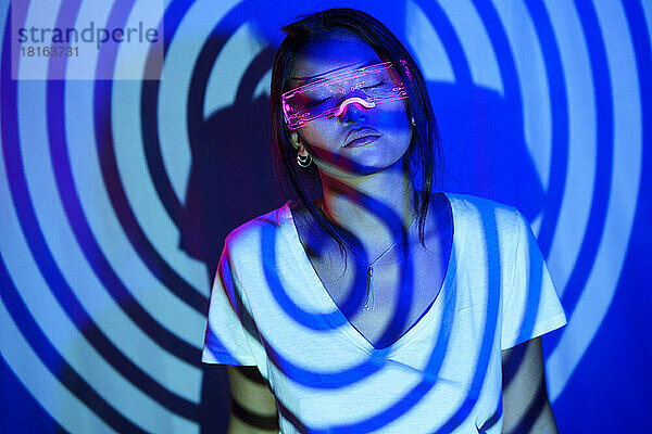 Spiral shadow on young woman wearing LED smart glasses