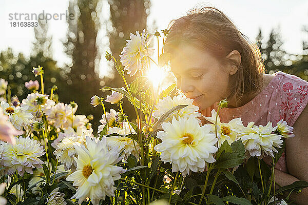 Woman smelling flowers in garden