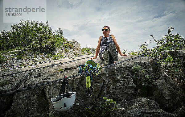 Reife Frau entspannt sich auf einem Felsen