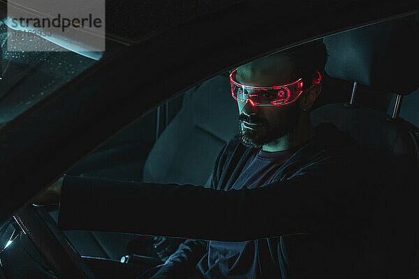 Mann mit beleuchteter Smart-Brille sitzt im Auto