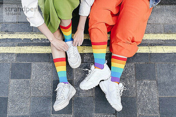 Young lesbian couple wearing multi colored socks at footpath