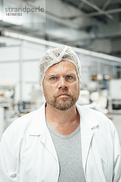 Mann mit Laborkittel und Brille in der Industrie